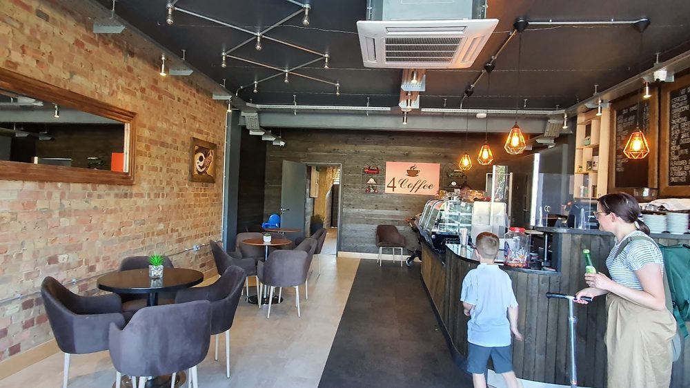 The seating area at 4 Coffee, with exposed brick, grey armchairs and low tables