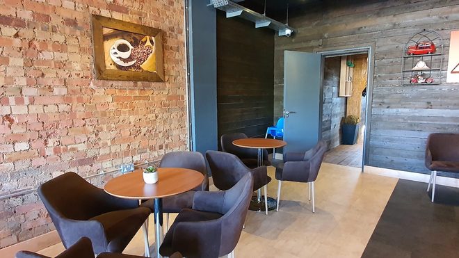 A round table with tub armchairs against the exposed brick wall